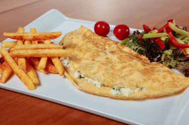 Lezzetli omlet ve kahvaltı tabağı masada..