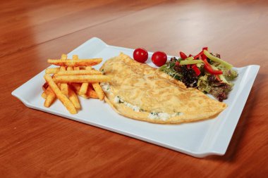 Lezzetli omlet ve kahvaltı tabağı masada..