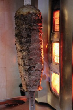 Bir aşçı doğruyor, kebap yapıyor.