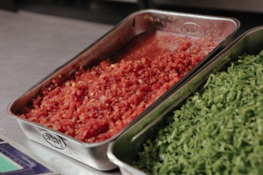 Çelik kaplarda sebze ve et.