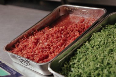 Çelik kaplarda sebze ve et.