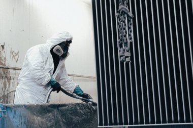 Fabrika, çalışanlar iş yerinde kimyasal koruyucu giysi giyerler. Boya püskürtme.