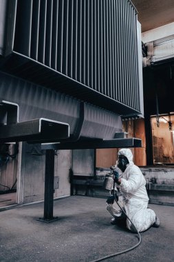 Fabrika, çalışanlar iş yerinde kimyasal koruyucu giysi giyerler. Boya püskürtme.