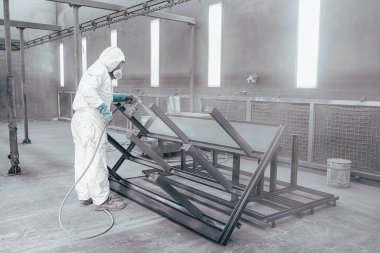 Fabrika, çalışanlar iş yerinde kimyasal koruyucu giysi giyerler. Boya püskürtme.