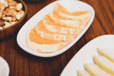 Lezzetli karışık meyveler ve dilimlenmiş meyvelerle dolu bir tabak.