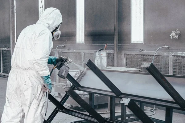 Fabrika, çalışanlar iş yerinde kimyasal koruyucu giysi giyerler. Boya püskürtme.