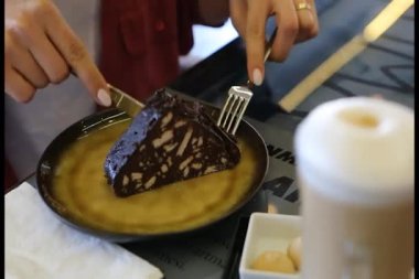 Genç bir kadın mozaik bir pasta dilimleyip yiyor..
