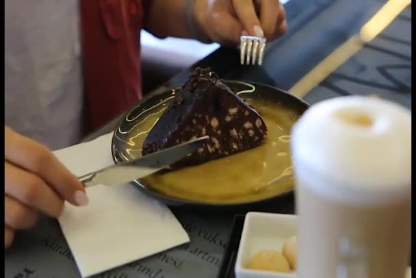 若い女性がモザイクケーキをスライスして食べています — ストック動画