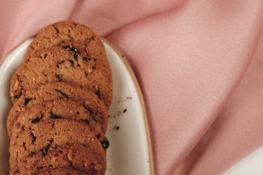 Bir grup çeşit kurabiye. Çikolata parçacıklı, yulaflı, kuru üzümlü, beyaz çikolatalı.