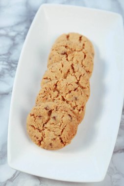 Bir grup çeşit kurabiye. Çikolata parçacıklı, yulaflı, kuru üzümlü, beyaz çikolatalı.