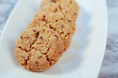 Bir grup çeşit kurabiye. Çikolata parçacıklı, yulaflı, kuru üzümlü, beyaz çikolatalı.