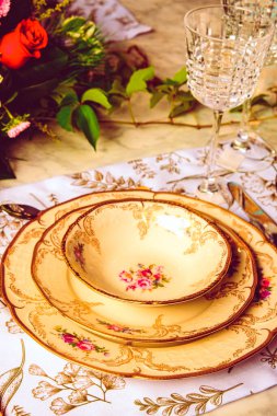 Güzel bir tabak ve mükemmel renkte çiçekler lüks bir masada duruyor.