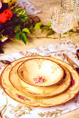 Güzel bir tabak ve mükemmel renkte çiçekler lüks bir masada duruyor.