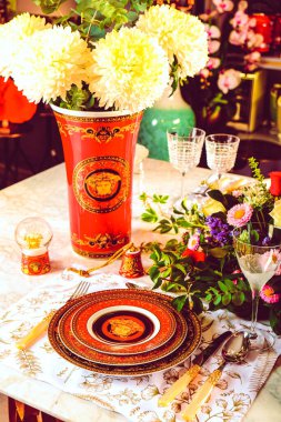 Güzel bir tabak ve mükemmel renkte çiçekler lüks bir masada duruyor.