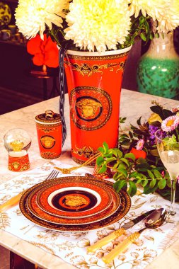 Güzel bir tabak ve mükemmel renkte çiçekler lüks bir masada duruyor.