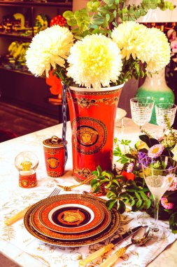 Güzel bir tabak ve mükemmel renkte çiçekler lüks bir masada duruyor.