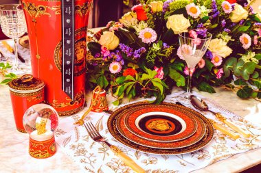 Güzel bir tabak ve mükemmel renkte çiçekler lüks bir masada duruyor.