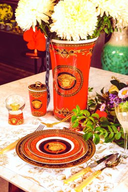 Güzel bir tabak ve mükemmel renkte çiçekler lüks bir masada duruyor.