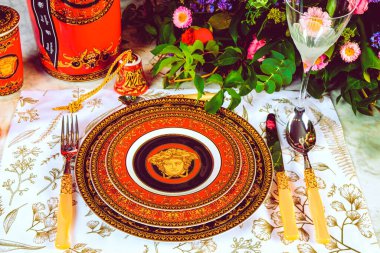 Güzel bir tabak ve mükemmel renkte çiçekler lüks bir masada duruyor.