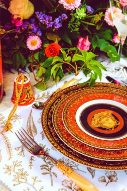 Güzel bir tabak ve mükemmel renkte çiçekler lüks bir masada duruyor.