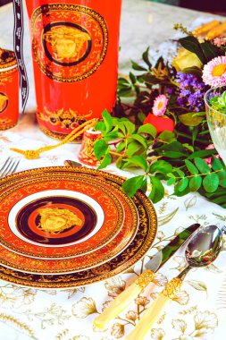 Güzel bir tabak ve mükemmel renkte çiçekler lüks bir masada duruyor.