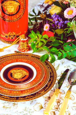 Güzel bir tabak ve mükemmel renkte çiçekler lüks bir masada duruyor.