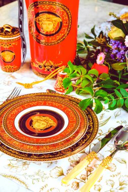 Güzel bir tabak ve mükemmel renkte çiçekler lüks bir masada duruyor.