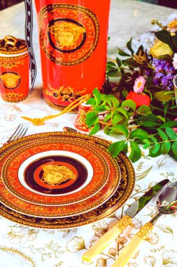 Güzel bir tabak ve mükemmel renkte çiçekler lüks bir masada duruyor.