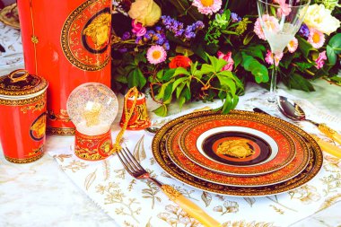 Güzel bir tabak ve mükemmel renkte çiçekler lüks bir masada duruyor.