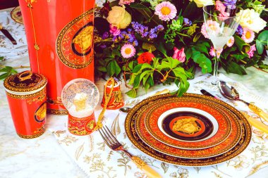 Güzel bir tabak ve mükemmel renkte çiçekler lüks bir masada duruyor.