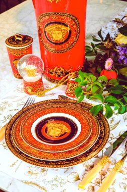 Güzel bir tabak ve mükemmel renkte çiçekler lüks bir masada duruyor.