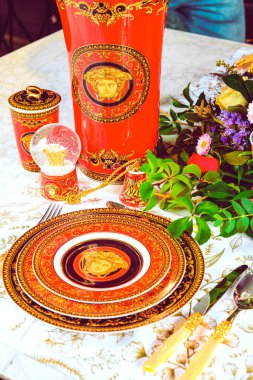 Güzel bir tabak ve mükemmel renkte çiçekler lüks bir masada duruyor.