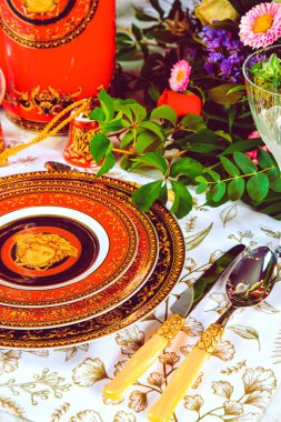 Güzel bir tabak ve mükemmel renkte çiçekler lüks bir masada duruyor.