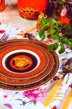 Güzel bir tabak ve mükemmel renkte çiçekler lüks bir masada duruyor.