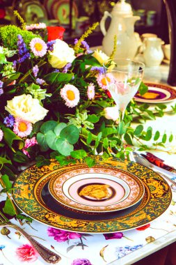 Güzel bir tabak ve mükemmel renkte çiçekler lüks bir masada duruyor.