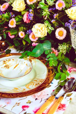 Güzel bir tabak ve mükemmel renkte çiçekler lüks bir masada duruyor.