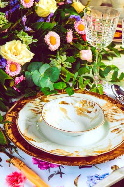 Güzel bir tabak ve mükemmel renkte çiçekler lüks bir masada duruyor.