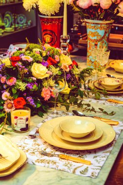 Güzel bir tabak ve mükemmel renkte çiçekler lüks bir masada duruyor.