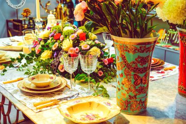 Güzel bir tabak ve mükemmel renkte çiçekler lüks bir masada duruyor.