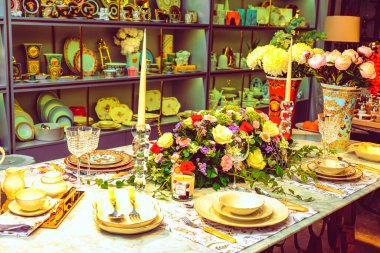 Güzel bir tabak ve mükemmel renkte çiçekler lüks bir masada duruyor.