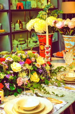 Güzel bir tabak ve mükemmel renkte çiçekler lüks bir masada duruyor.