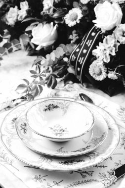 Güzel bir tabak ve mükemmel renkte çiçekler lüks bir masada duruyor.