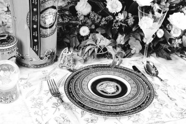 Güzel bir tabak ve mükemmel renkte çiçekler lüks bir masada duruyor.