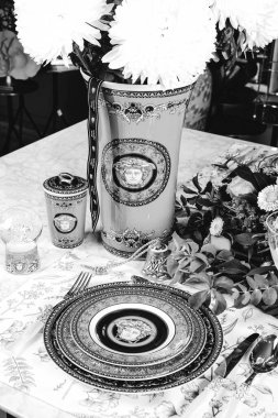 Güzel bir tabak ve mükemmel renkte çiçekler lüks bir masada duruyor.