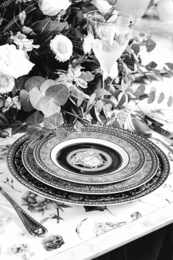 Güzel bir tabak ve mükemmel renkte çiçekler lüks bir masada duruyor.