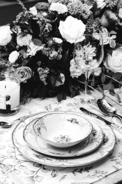 Güzel bir tabak ve mükemmel renkte çiçekler lüks bir masada duruyor.