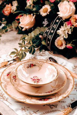 Güzel bir tabak ve mükemmel renkte çiçekler lüks bir masada duruyor.