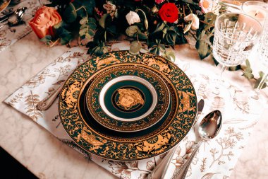 Güzel bir tabak ve mükemmel renkte çiçekler lüks bir masada duruyor.