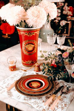 Güzel bir tabak ve mükemmel renkte çiçekler lüks bir masada duruyor.