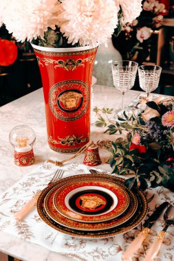 Güzel bir tabak ve mükemmel renkte çiçekler lüks bir masada duruyor.